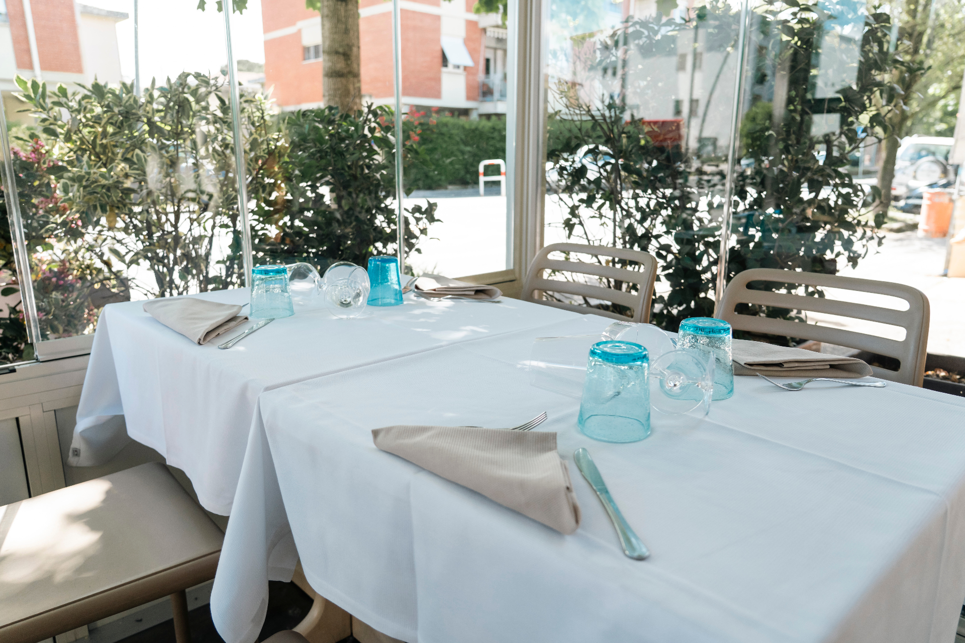 La veranda vetrata de La Degusteria con tavoli apparecchiati